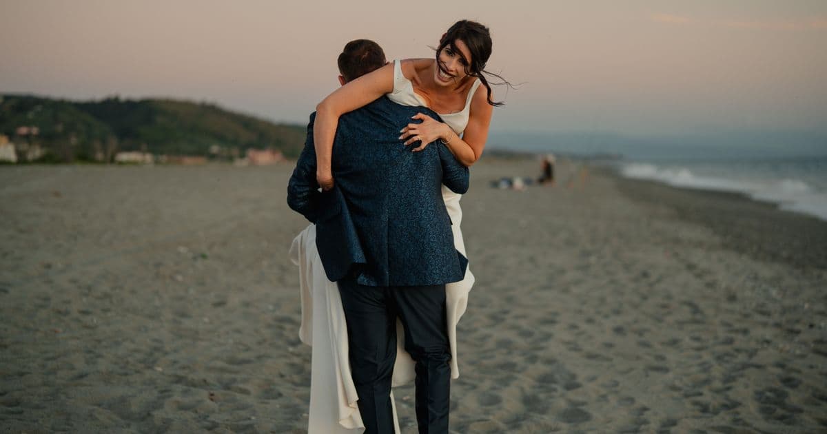 Couple on a beach at sunset for a destination wedding digital invitation