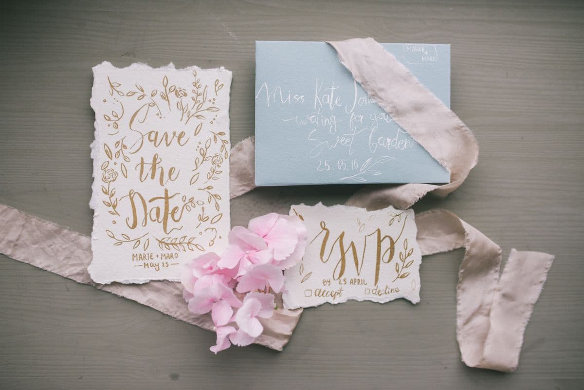 Save the date invitation card on a table with wedding planning details