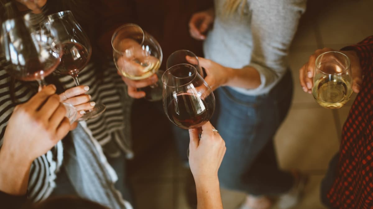 Couple toasting at a celebration with friends and warm lighting