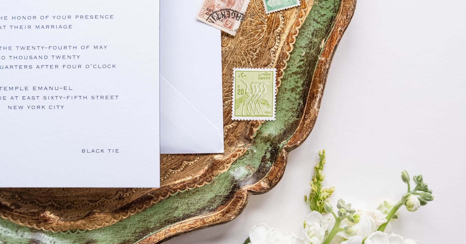 Formal wedding invitation card on a tray, used while comparing a Greenvelope alternative for digital wedding invites