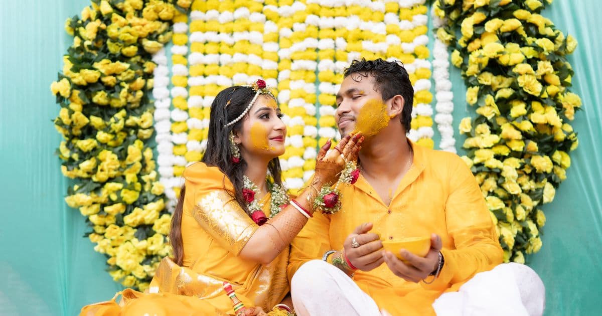 Bride and groom at vibrant haldi ceremony with turmeric paste — haldi ceremony invite WhatsApp guide