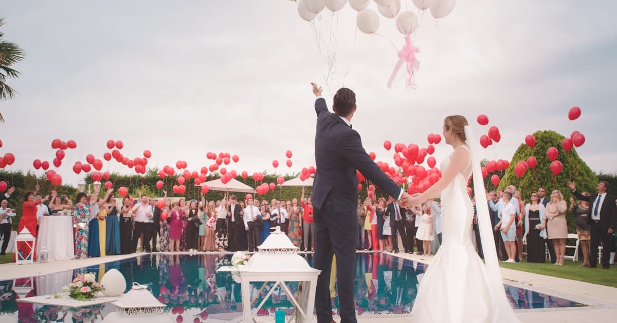 Couple comparing wedding website and digital invitation options on phone and laptop