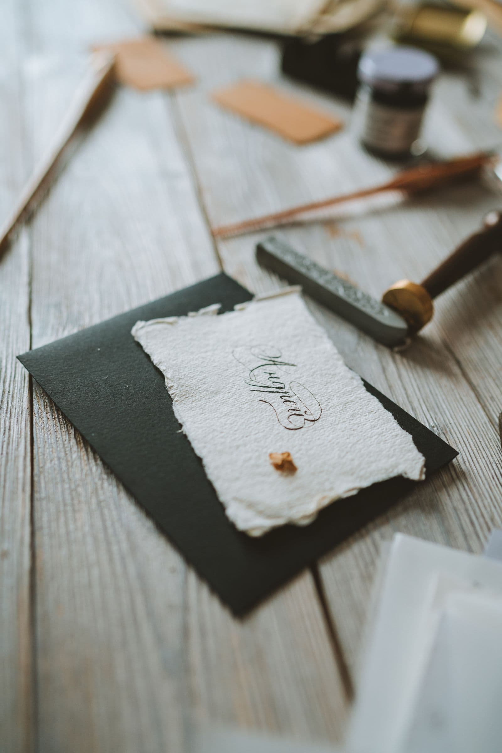 Calligraphy card and wax seal on a wooden desk for wedding invitation wording formal vs casual templates
