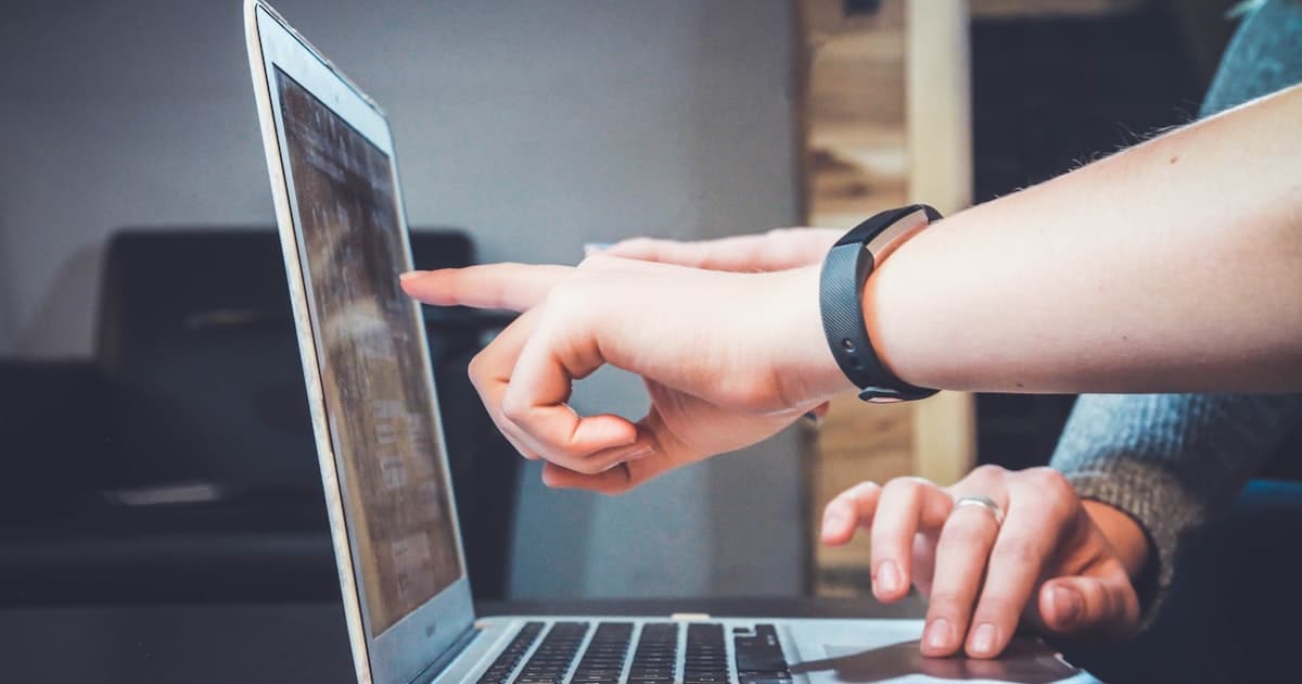 Couple planning wedding invitations on laptop — how to send wedding invitations by email