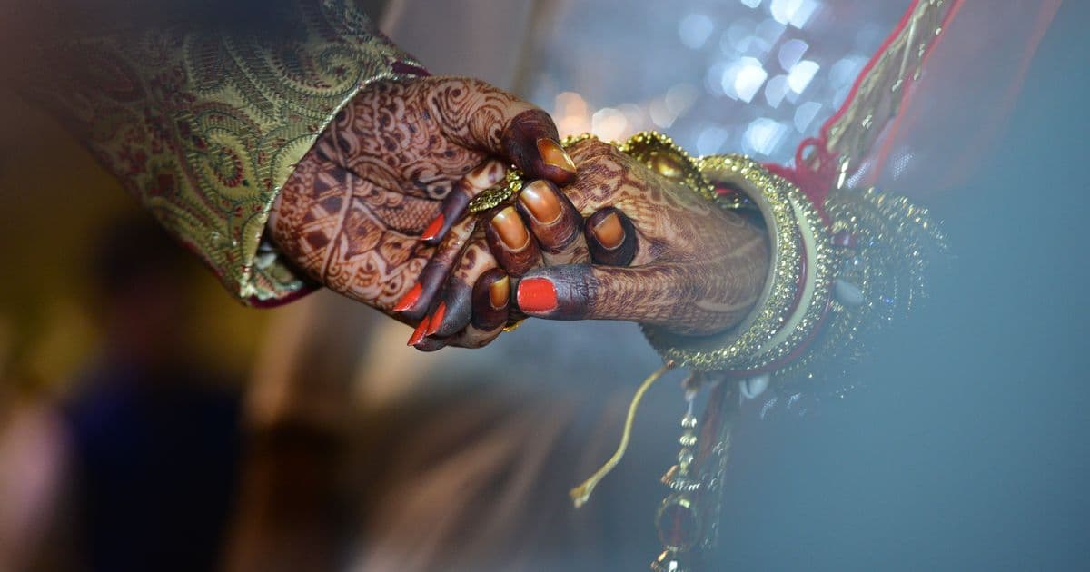 Indian wedding couple with mehendi and traditional jewelry — sangeet night invitation digital