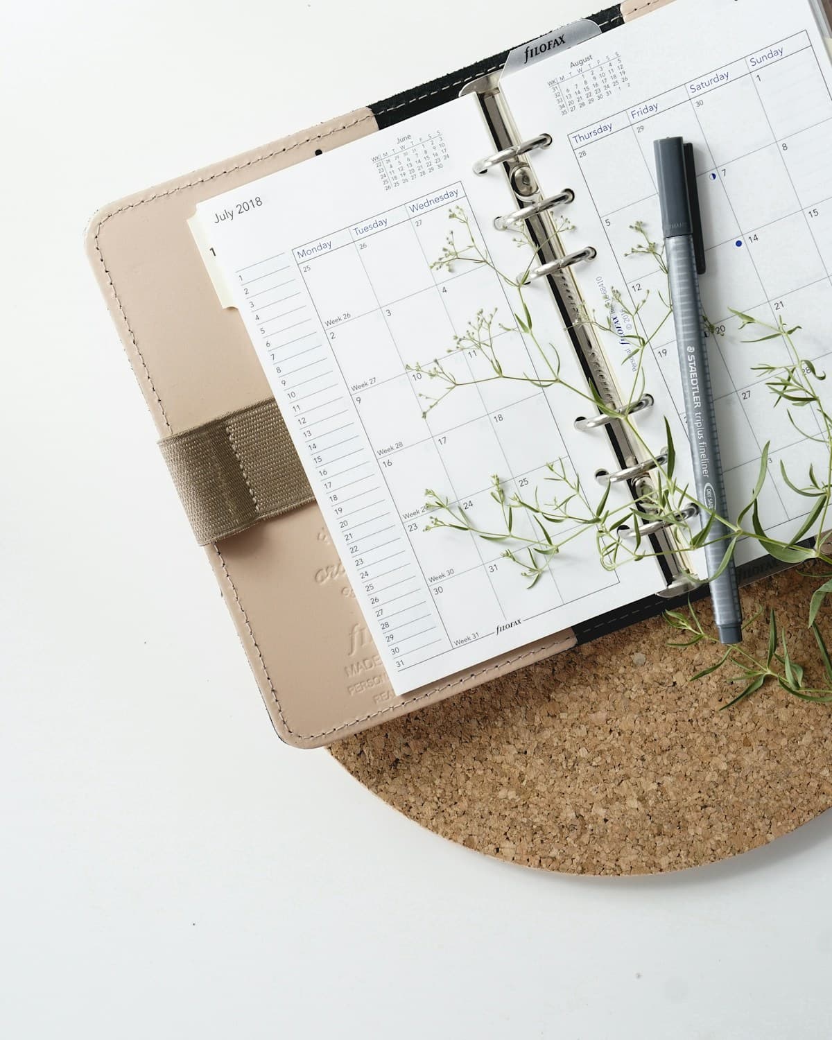 Wedding planning calendar with pen marking dates for when to send wedding invitations