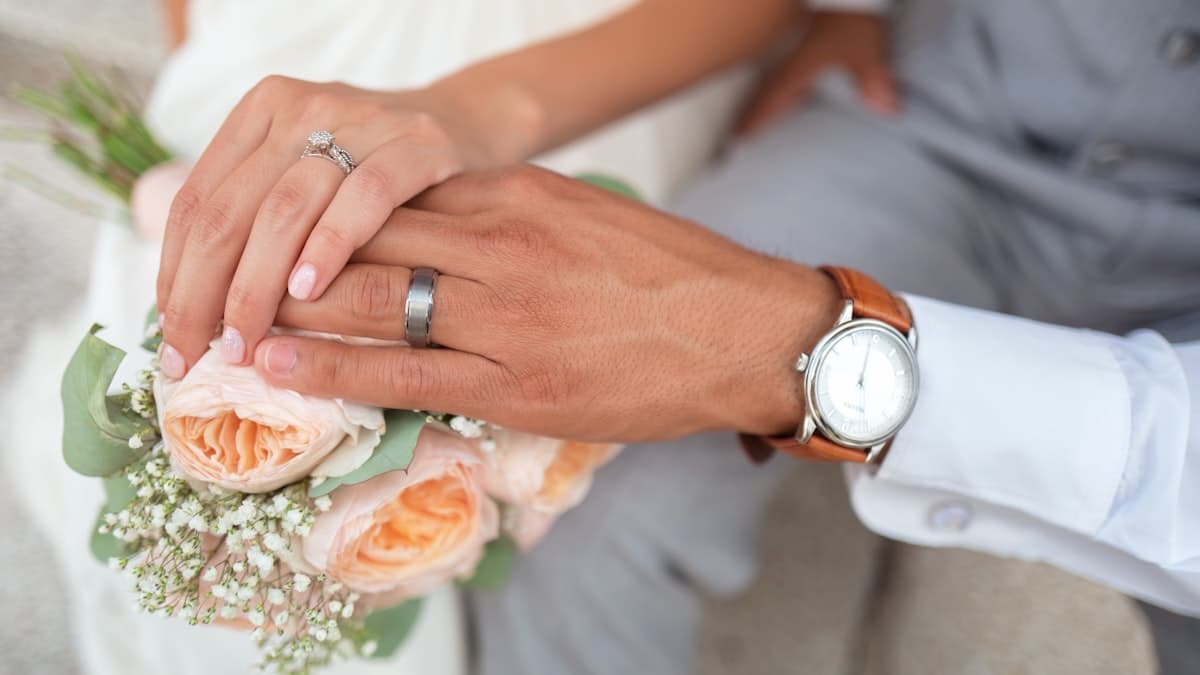 Wedding couple planning digital invitations together on laptop